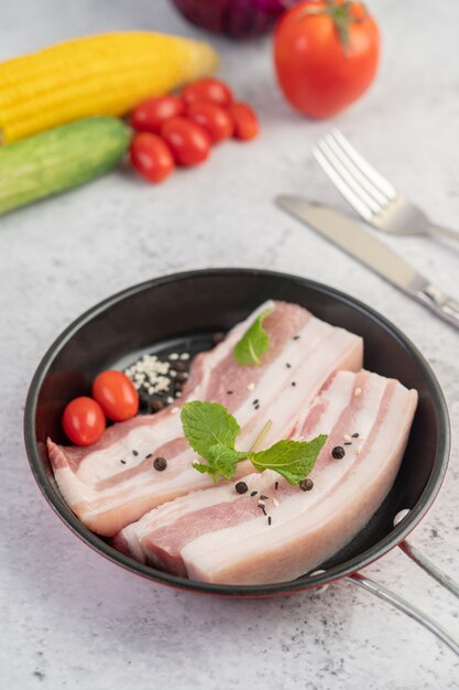 Barriga de porco em uma panela com sementes de pimenta Tomate e especiarias