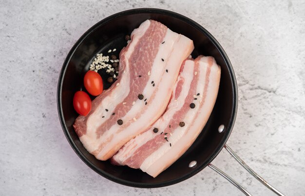 Barriga de porco em uma panela com sementes de pimenta Tomate e especiarias