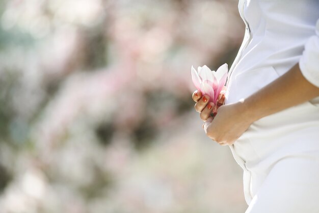 Barriga de uma mulher grávida e uma flor