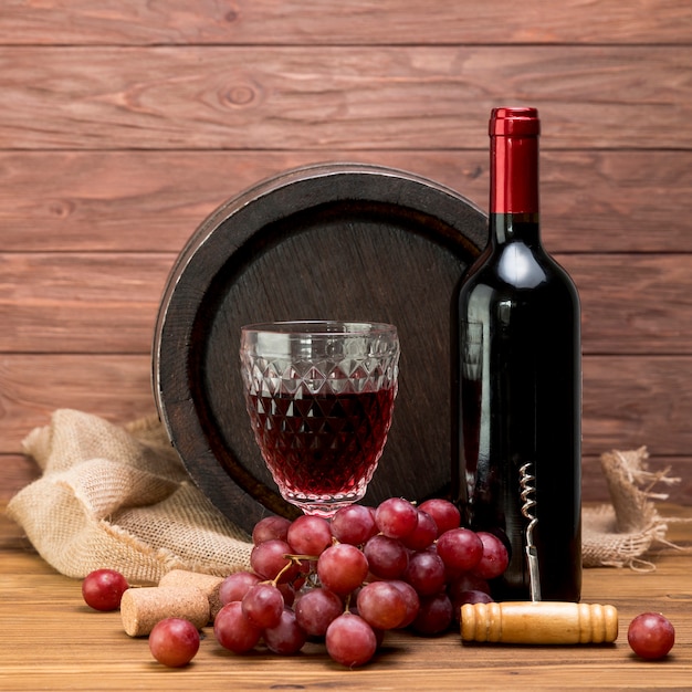 Barril de madeira com garrafa e copo de vinho