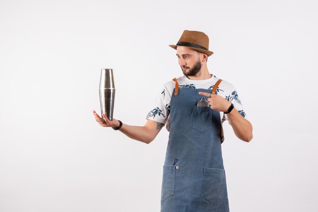 Bartender masculino segurando um shaker prata na parede branca modelo de bar de bebidas alcoólicas em clube noturno