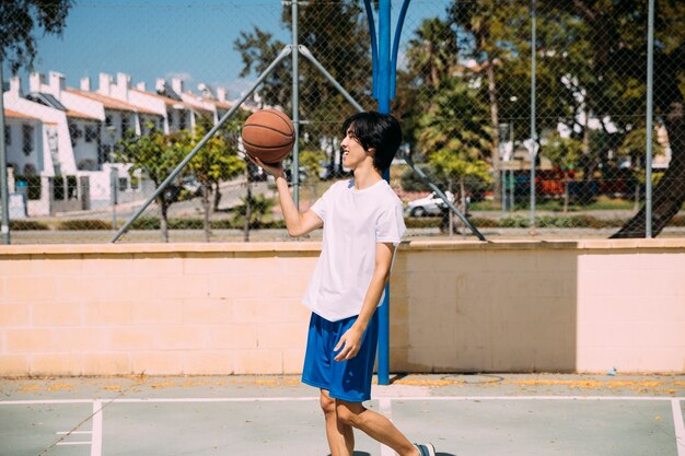 Basquete de exploração masculino étnica em pé no parque infantil