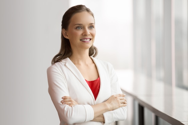 Bastante sorridente mulher de negócios que está no indicador