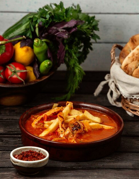 Batata com frango ao molho em uma mesa de madeira