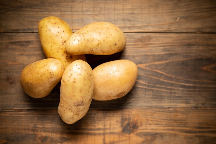 Foto grátis batata crua no fundo de madeira.