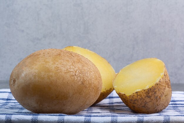 Batata inteira e fatiada no mármore.