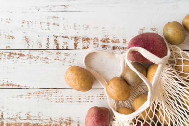 Batatas em saco branco têxtil com espaço de cópia