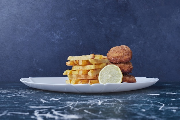 Batatas fritas com cotlets e limão.