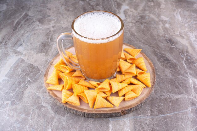 Batatas fritas crocantes com cerveja gelada na peça de madeira. Foto de alta qualidade