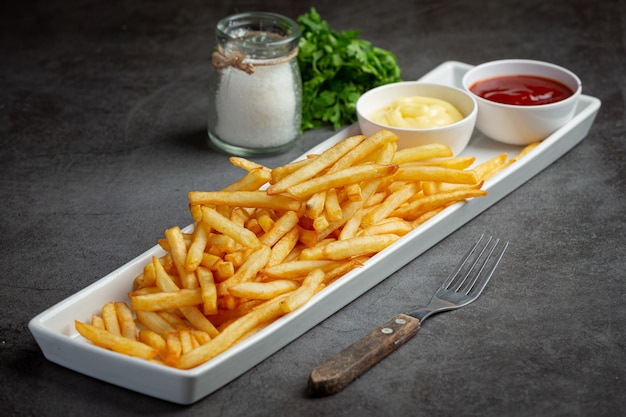 Batatas fritas crocantes com ketchup e maionese.