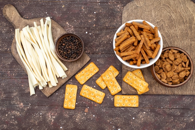 Batatas fritas e biscoitos com queijo sobre a mesa de madeira marrom biscoito crocante de foto