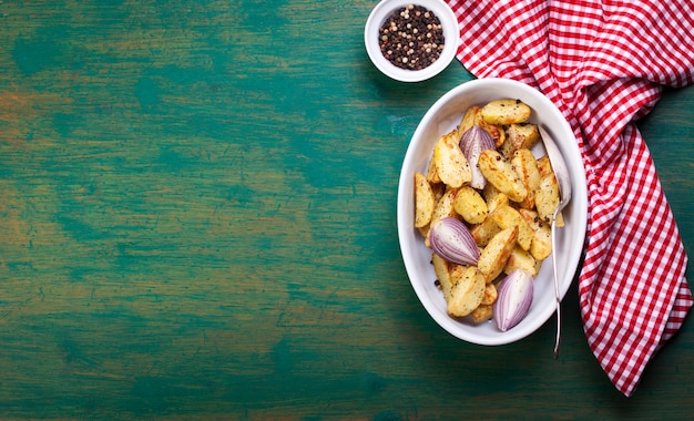 Batatas fritas em uma tigela e pimenta