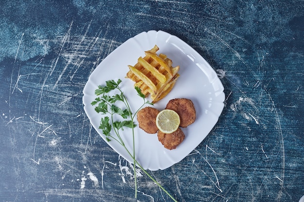 Batatas fritas, nuggets e ervas.