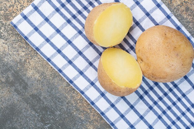 Batatas inteiras deliciosas cozidas na toalha de mesa. Foto de alta qualidade