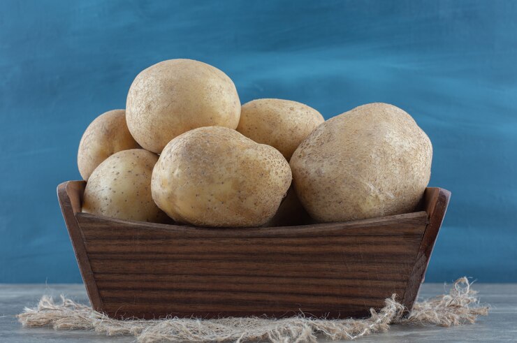 Foto grátis batatas na caixa, na toalha, na mesa de mármore.
