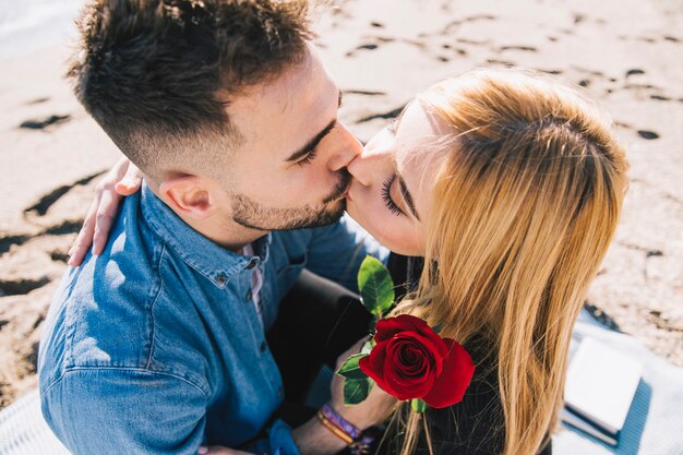 Beautiful kissing couple posando no litoral