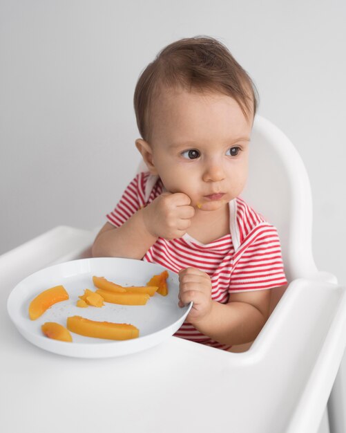 Bebê adorável brincando com comida