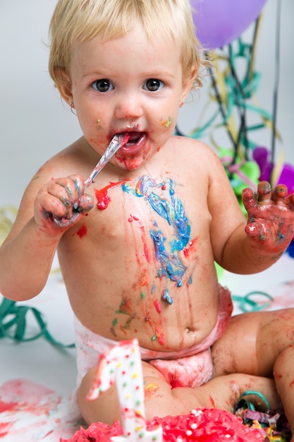 Bebé comemorando seu primeiro bithday com bolo gourmet e ba