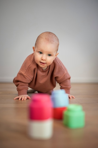 Foto grátis bebê de baixo ângulo engatinhando para brinquedos