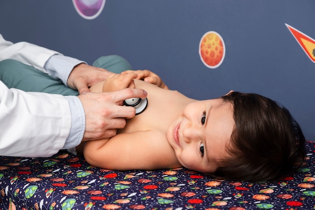 Foto grátis bebê de close-up sendo examinado com estetoscópio