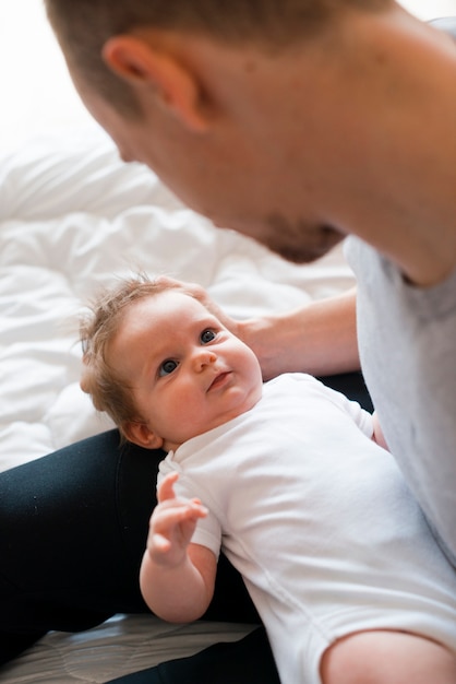 Foto grátis bebê deitado no colo do pai