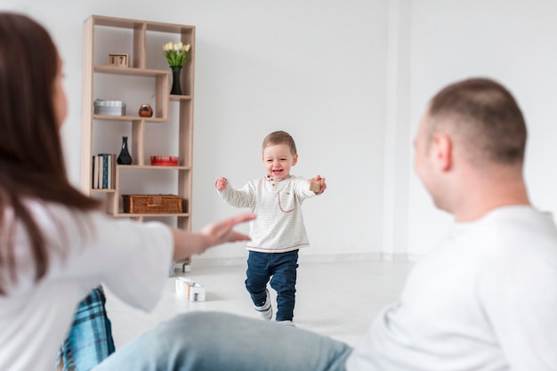 Foto grátis bebê feliz e pais em casa