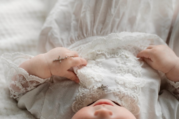 Foto grátis bebê fofo de alto ângulo segurando cruz