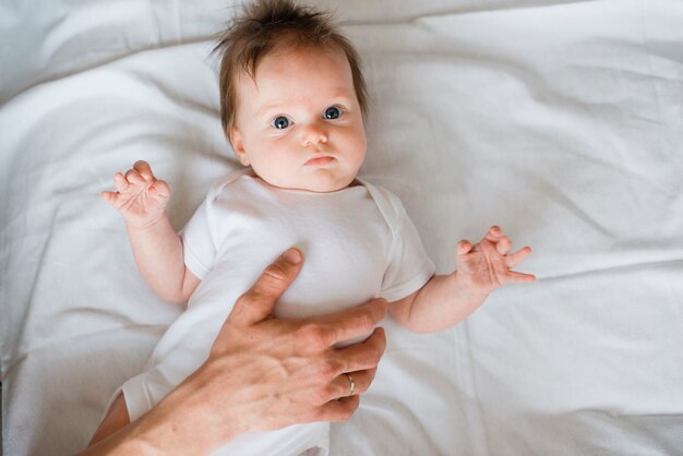 Bebê fofo deitado na cama