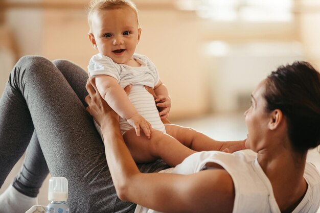 Bebê fofo se divertindo enquanto está com sua mãe na aula de ginástica no health club