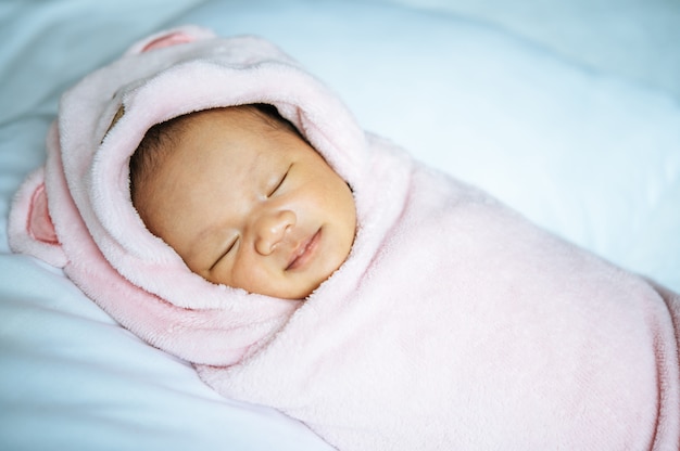 Bebê recém-nascido dormindo em um cobertor rosa suave