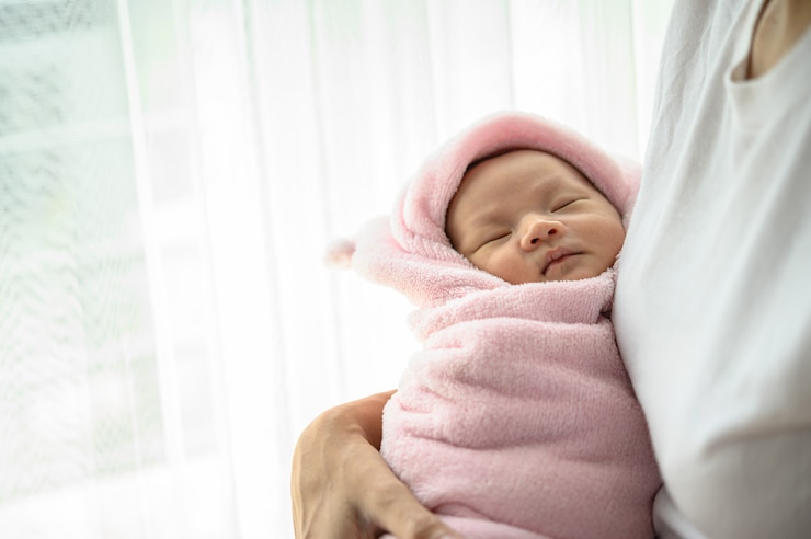Foto grátis bebê recém-nascido dormindo no abraço da mãe