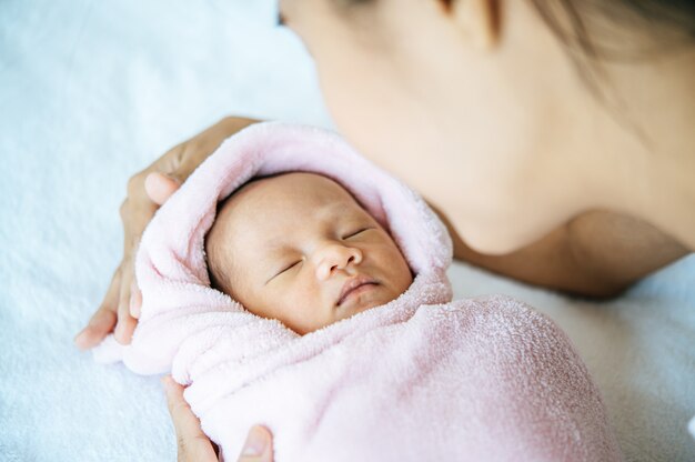 bebê recém-nascido dormindo nos braços da mãe