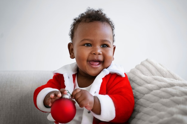 Bebê sorridente de vista frontal vestindo roupa de papai noel