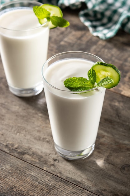 Bebida ayran com hortelã e pepino em vidro na mesa de madeira