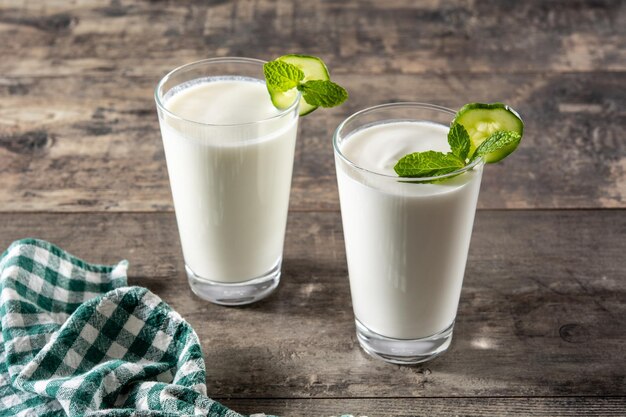 Bebida ayran com hortelã e pepino em vidro na mesa de madeira