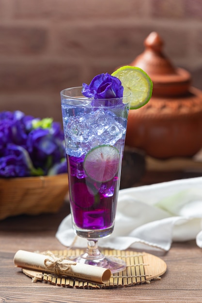 Bebida saudável, chá de flor de ervilha azul orgânica com limão e lima.