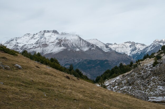 Bela cadeia de altas montanhas rochosas cobertas de neve durante o dia