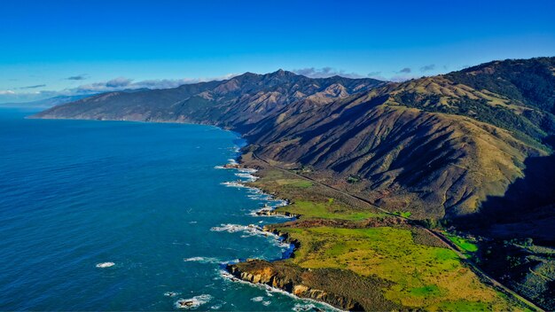 Bela foto aérea da costa do mar com folhas verdes e céu nublado incrível