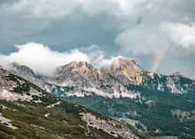 Foto grátis bela foto da montanha arborizada sob um céu azul nublado em grober priel
