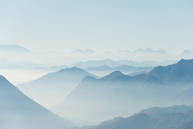 Bela foto de altas colinas brancas e montanhas cobertas de nevoeiro