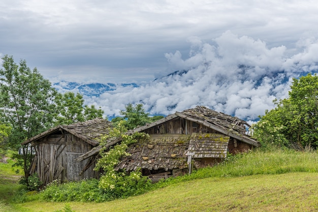 Bela foto de antigas casas de fazenda de madeira nas montanhas em um dia nublado no Tirol do Sul, Itália