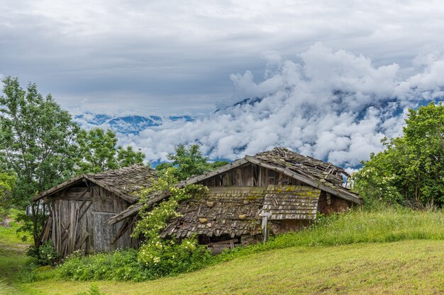 Bela foto de antigas casas de fazenda de madeira nas montanhas em um dia nublado no Tirol do Sul, Itália