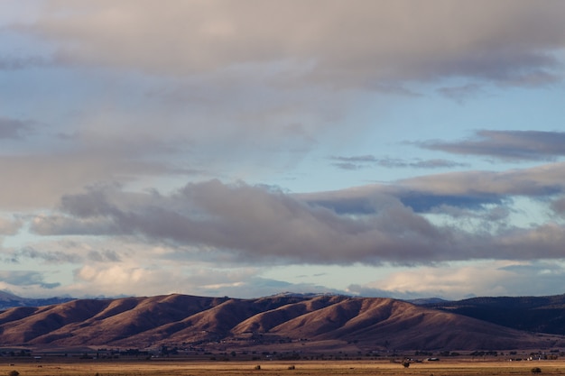 Bela foto de colinas íngremes de um deserto com incrível céu nublado