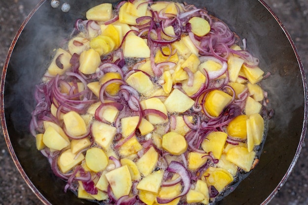 Bela foto de comida sendo preparada ao ar livre no fogão