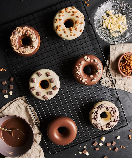 Foto grátis bela foto de deliciosos donuts cobertos de esmalte com os ingredientes em uma mesa