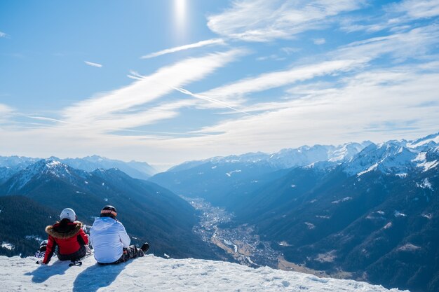 Bela foto de duas pessoas apreciando a vista das montanhas e do vale durante o dia