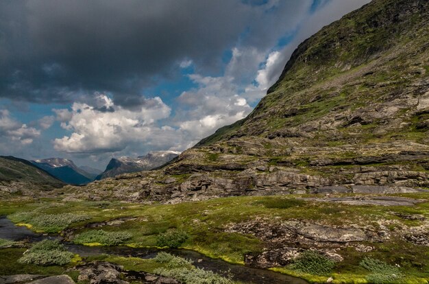 Bela foto de formações rochosas altas cobertas com grama na Noruega