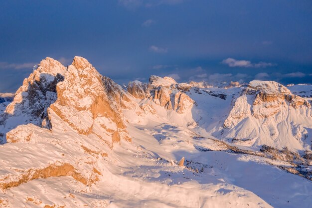 Bela foto de montanhas cobertas de neve ao pôr do sol