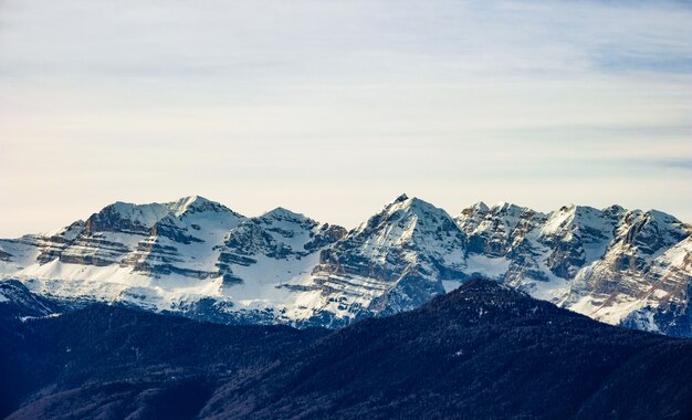 Bela foto de montanhas cobertas de neve em um dia ensolarado com céu claro ao fundo