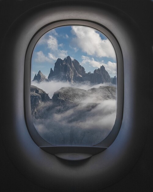 Bela foto de montanhas e céu nublado de dentro das janelas do avião